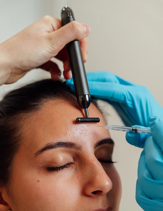 Dermatologist performing microneedling procedure on woman's forehead for skin rejuvenation treatment - Botox and wrinkle relaxers in New York, NY