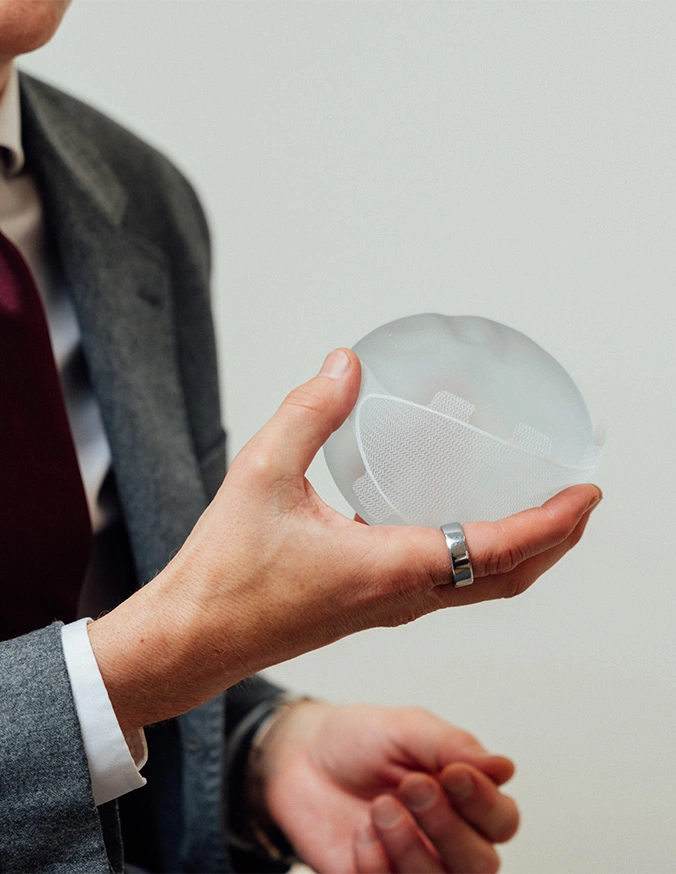 Doctor Craig Baldenhofer holding a breast implant in his hand. - Breast augmentation in New York, NY