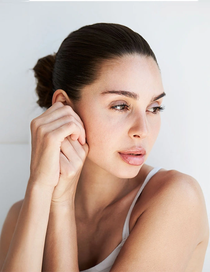 Woman with clear glowing skin touching face demonstrating natural beauty and skincare routine - Morpheus 8 in New York, NY